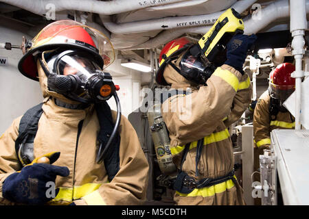 Océan Pacifique (fév. 13, 2018) marins affectés à la classe Arleigh Burke destroyer lance-missiles USS Dewey (DDG 105) répondre à une simulation d'incendie dans la classe bravo principal des machines du navire Numéro de chambre une pendant un exercice d'incendie de l'espace principal. Dewey est sur un déploiement prévu de mener des opérations dans la région Indo-Pacifique. Il permettra également de soutenir le groupe expéditionnaire Wasp (ESG) pour l'avance de la Flotte du Pacifique américaine Up-Gunned concept ESG et va former avec l'avant-déployés dans tous les navires amphibies les zones de mission. (U.S. Navy Banque D'Images