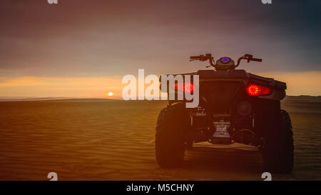 Retour d'un VTT sur le sable regardant le coucher du soleil au Pérou Banque D'Images