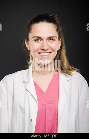 Jeune médecin portrait portant robe et des gommages corporels smiling sur fond noir