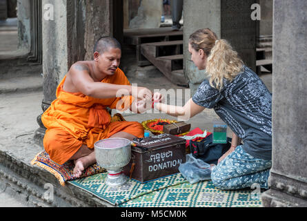 Le moine bouddhiste donne bénédiction à un tourisme de l'Ouest à Angkor Wat, au Cambodge Banque D'Images