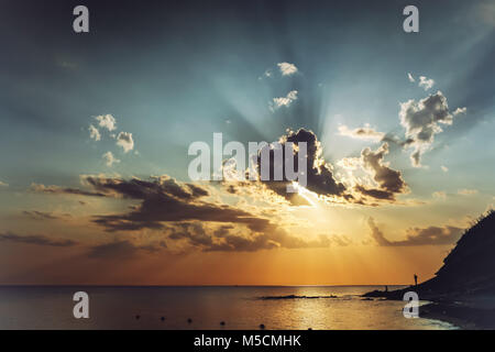 Pré-soirée sunset seascape avec de beaux nuages dans le ciel et les rayons du soleil passant à travers eux. La tonalité de l'image. Banque D'Images