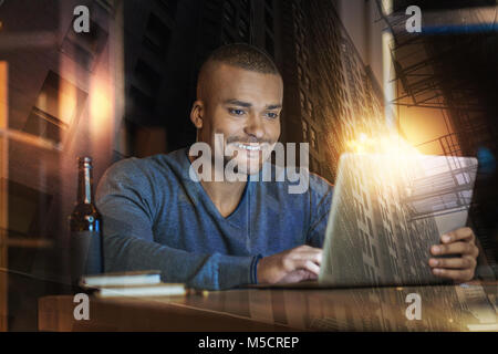 Jeune homme se sentir heureux tout en regardant l'écran d'un ordinateur portable Banque D'Images