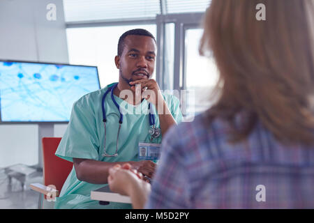 Chirurgien mâle parler à female patient in hospital Banque D'Images