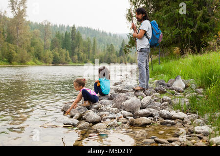 Père et filles randonnées, reposant à Lakeside Banque D'Images