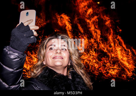 Jolie femme prend un en face de selfies un grand incendie lors d'une fête du village de nuit Banque D'Images