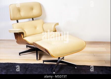 Velours rouge moderne fauteuil avec pouf en mur blanc salle intérieure Banque D'Images