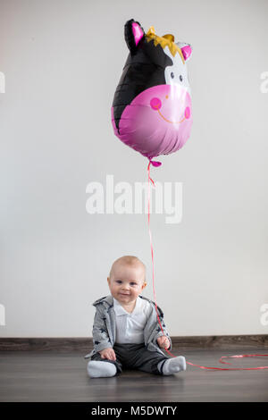 Petit bébé garçon aux grands ballon, assis sur le plancher à la maison Banque D'Images