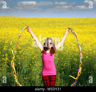 Happy little girl waving avec des rubans colorés de la saison du printemps Banque D'Images