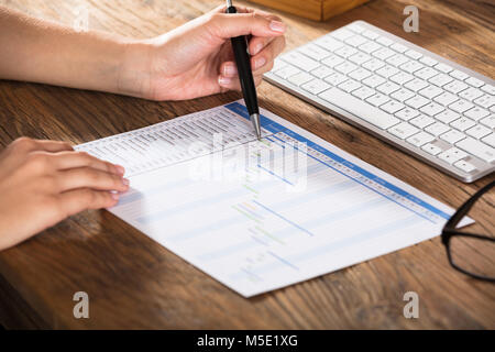 Close-up de l'homme d'affaires d'analyser le graphique de Gantt sur un bureau en bois Banque D'Images