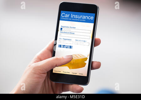 Businesswoman Remplissage du formulaire d'assurance auto On Cell Phone Banque D'Images