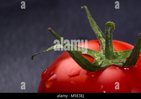 Tomates mûres fraîches sur fond noir, macro photo Banque D'Images