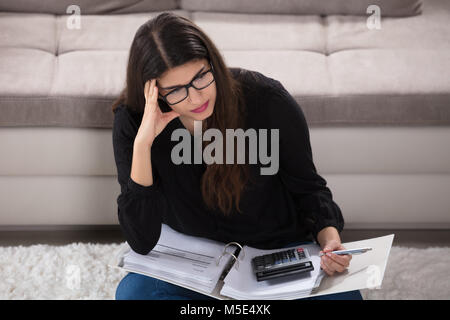 Jeune femme envisage des projets de calcul à la maison Banque D'Images