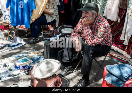 Vieil homme assis en attente de clients au marché aux puces de Yerevan, Arménie Banque D'Images