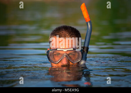Portrait de porter des lunettes de plongée et snorkeling sur la surface de l'eau Banque D'Images