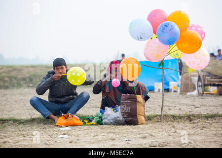 Un Hawker et son fils la préparation de leurs ballons colorés au village juste à bogra, Bangladesh. Banque D'Images