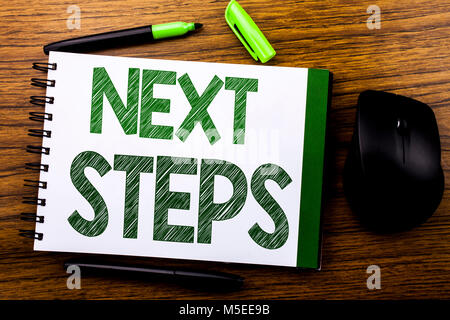Texte d'annonce de l'écriture manuscrite indiquant les prochaines étapes. Concept d'affaires pour les futurs Golas et cible écrit sur papier de l'ordinateur portable note book on wooden backgroun Banque D'Images