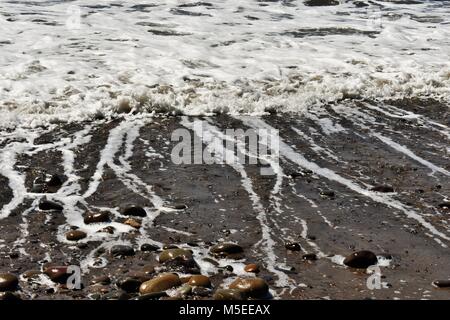 L'eau de l'océan s'éloignant de la rive. Ventura State Beach, Californie Banque D'Images