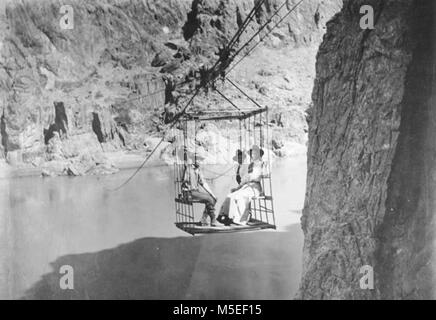 Grand Canyon Colorado River- Historique de passage de câble c'EST LA ROUILLE TÉLÉPHÉRIQUE traversant le fleuve du Colorado, DU SUD AU NORD. 2 femmes et 1 HOMME EN CAGE. Vers 1908. KOLB BROS. Banque D'Images