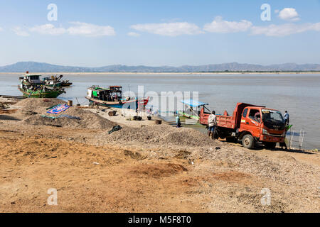 Bagan, Myanmar, 27 Décembre 2017 : Les travailleurs sable sur bateau sur l'embarcadère de la rivière Irrawaddy Banque D'Images