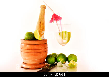 Cocktail avec des citrons verts sur fond blanc. Banque D'Images