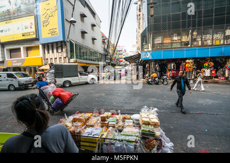 Une femme vendant des biens dans un petit stand sur une rue de Bangkok Banque D'Images