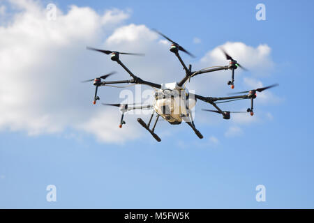 L'agriculture, de vol de drone drone photo image de l'agriculture portent un réservoir d'engrais liquide volant dans le ciel bleu se préparent à le vaporiser dans l'agriculture sont Banque D'Images