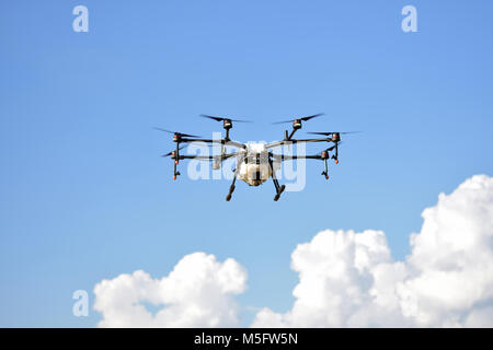 L'agriculture, de vol de drone drone photo image de l'agriculture portent un réservoir d'engrais liquide volant dans le ciel bleu se préparent à le vaporiser dans l'agriculture sont Banque D'Images