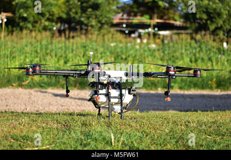 L'agriculture, drone drone photo image de l'agriculture portent un réservoir d'engrais liquide gratuit sur herbe verte sol préparer pour vaporiser un insecticide en agriculture sont Banque D'Images