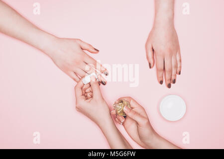 Cropped shot de manucure ongles polonais sur l'application de client isolé sur pink Banque D'Images