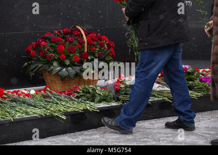 Roses rouges et sportifs symbole de deuil - jeter des fleurs au monument Banque D'Images