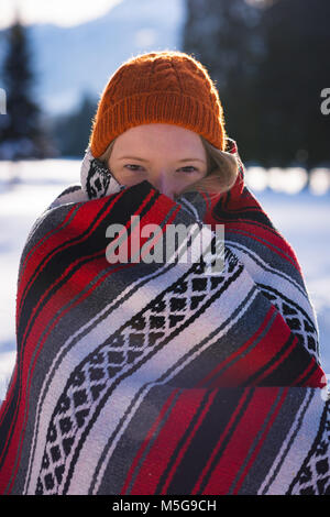 Woman wrapped in blanket in snow Banque D'Images