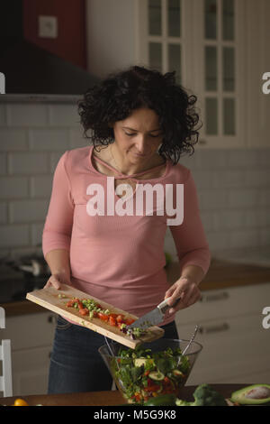 Woman preparing vegetable salad in kitchen Banque D'Images