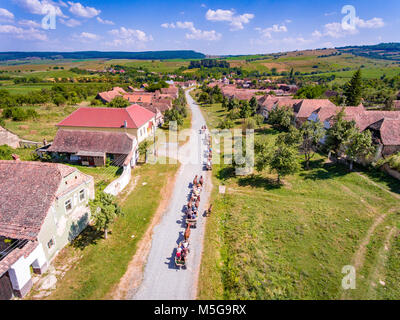 Les touristes en cariages avec les chevaux voyageant à travers Mesendorf Village Saxon dans l'été Banque D'Images