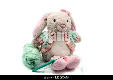 Lapin de Pâques avec des vêtements au crochet et de la laine en boule sur fond blanc isolé. Banque D'Images