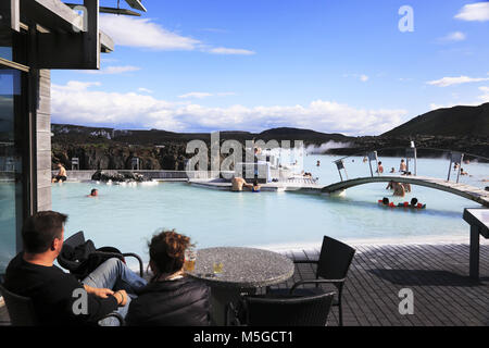 Les visiteurs vous détendre dans le spa géothermique Blue Lagoon de la centrale géothermique de Svartsengi en arrière-plan.près de Reykjavik en Islande. Banque D'Images