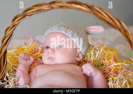 Naissance bebe Fille pose dans le panier de Pâques lapin en tricot fait main port outfit Banque D'Images