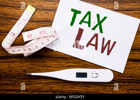 La légende de texte écrit conceptuel montrant le droit fiscal. Concept d'imposition de taxes règle écrite sur papier sticky note de fond bois. Mètre et Banque D'Images