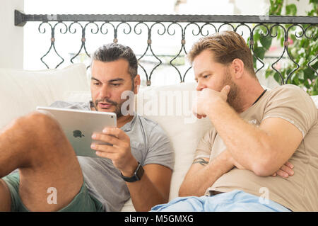 Didim, Turquie - 01 octobre 2017 : deux hommes occasionnels avec un iPad de discuter sur un projet d'affaires dans le balcon sur une journée ensoleillée. Banque D'Images