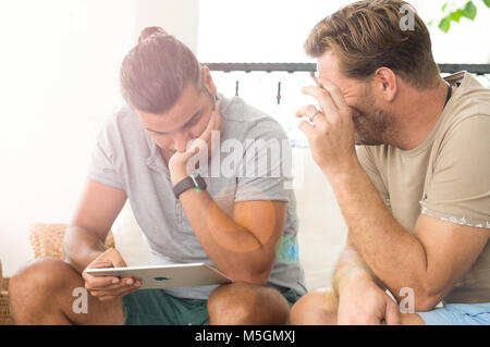Didim, Turquie - 01 octobre 2017 : deux hommes occasionnels avec un iPad de discuter sur un projet d'affaires dans le balcon sur une journée ensoleillée. Banque D'Images