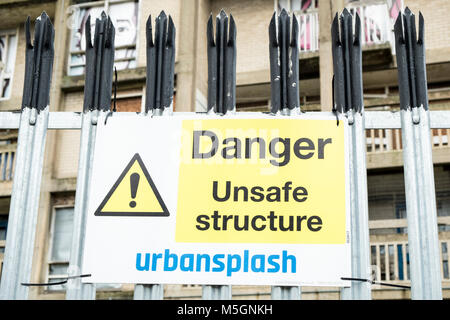 Danger, structure dangereuse signe par Urban Splash sur des barrières de sécurité avec des bâtiments derrière qui ont été déclarés dangereux, Park Hill, Sheffield, Royaume-Uni Banque D'Images