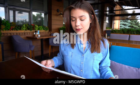 Pretty woman reading menu au restaurant avec close up face Banque D'Images