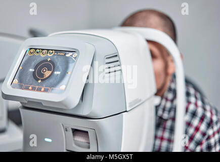 L'homme vérifie sa vision sur la machine Banque D'Images