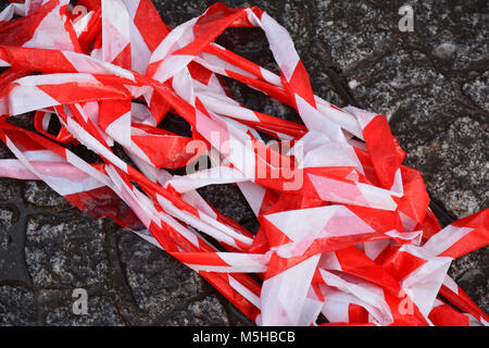 Une pile de ruban de signalisation rouge et blanc sur le sol Banque D'Images