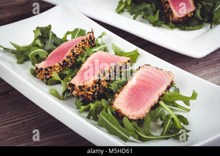 Tataki de thon en croûte de sésame sur fond bois plaque apéritif Banque D'Images