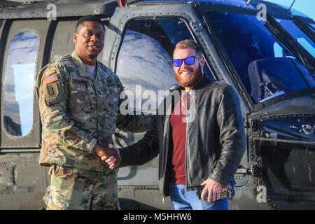 Le capitaine de l'armée américaine Andre Stevenson, à gauche, se dresse avec le Cpl. Rory Hamill, un blessé au combat Marine, en face d'une Garde nationale du New Jersey UH-60L Black Hawk sur Joint Base McGuire-Dix-Lakehurst, N.J., le 21 décembre 2017. (U.S. Air National Guard Banque D'Images