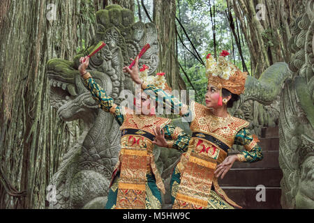 Danseurs balinais sur le Dragon Bridge avec ficus racines, forêt des singes sacrés Sanctuaire, Ubud, Bali Banque D'Images