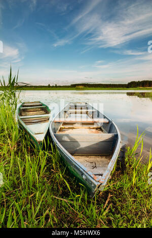 Paysage avec deux bateaux en bois sur une rivière, sous un ciel d'été bleu Banque D'Images