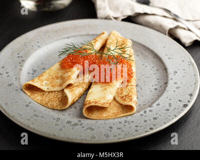 Blinis russe avec caviar rouge et l'aneth sur un gros plan de la plaque gris Banque D'Images