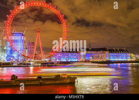 Londres, Royaume-Uni, le 17 février 2018 : UK Skyline dans la soirée. Éclairage de la London Eye et la Tamise à côté de bâtiments Banque D'Images