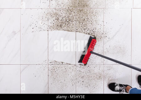 Balai de nettoyage de salissures sur le carrelage à la maison Banque D'Images